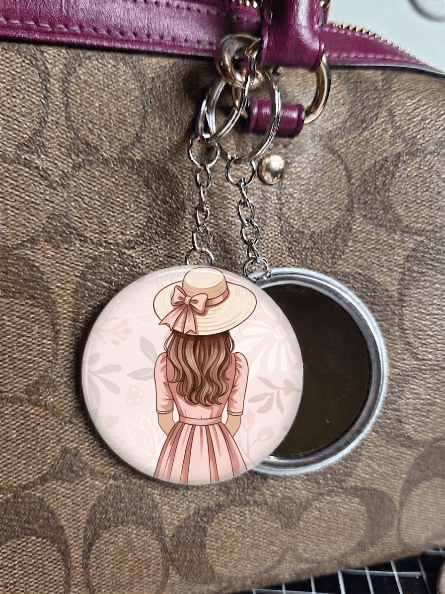 mirror keyring with a design of a woman wearing a hat on a patterned surface