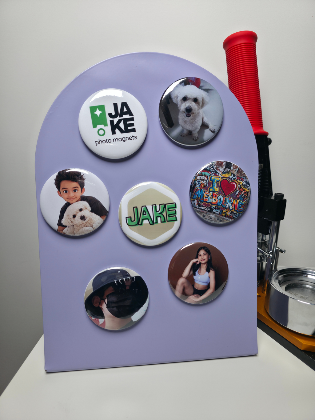 Purple board with various round magnets featuring images and text, including a dog and 'JAKE'.