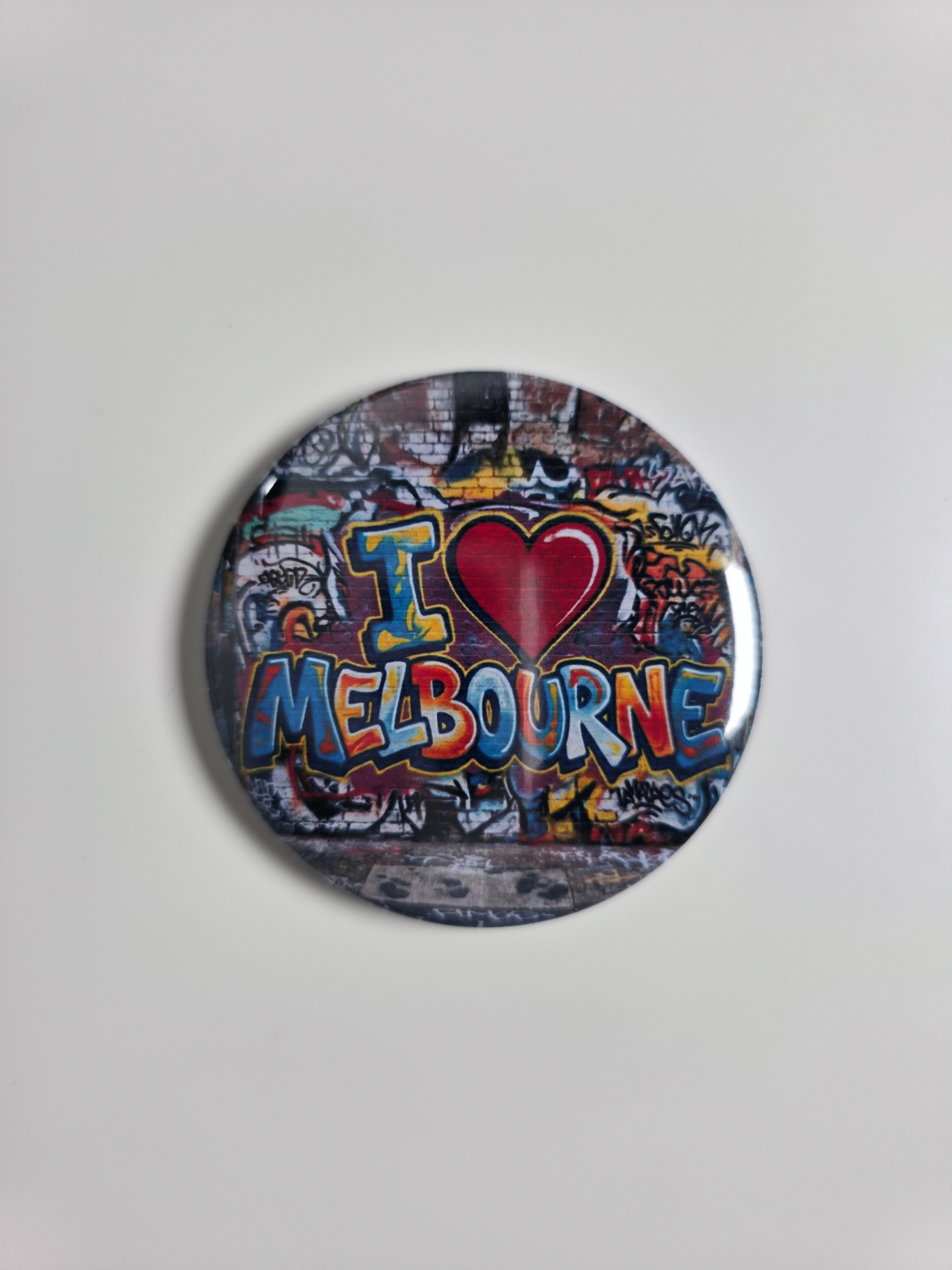 Round magnet with 'I ❤️ Melbourne' text on a colourful background