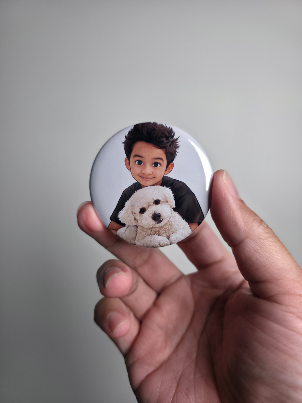 round photo magnet with a person and dog illustration held by a hand against a plain background