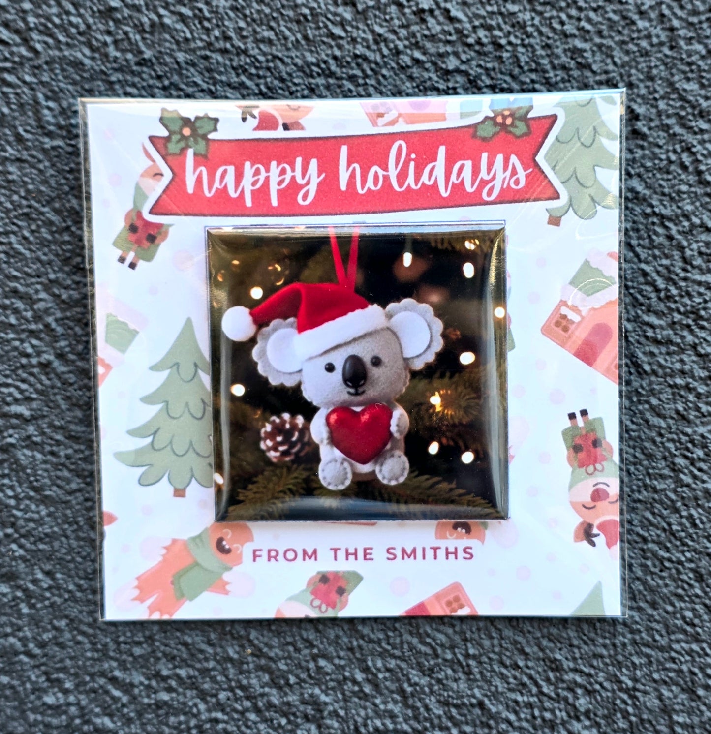 Christmas-themed ornament packaging with 'happy holidays' text and a koala design.