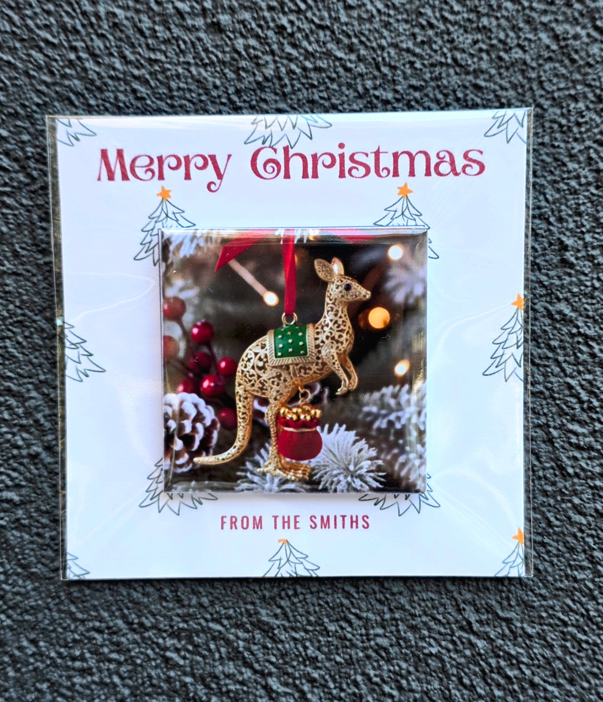 Christmas card with a kangaroo ornament and 'Merry Christmas' text on a textured surface.
