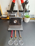Keychain making machine on a table with keychains hanging below