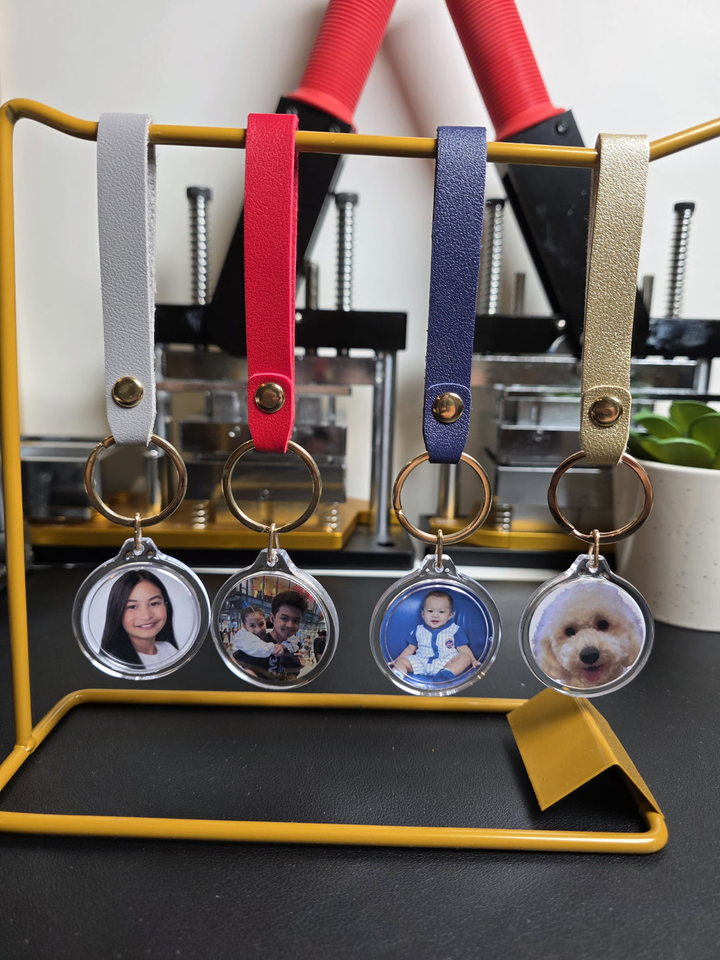 Keychains with photo charms on a stand with colorful straps.