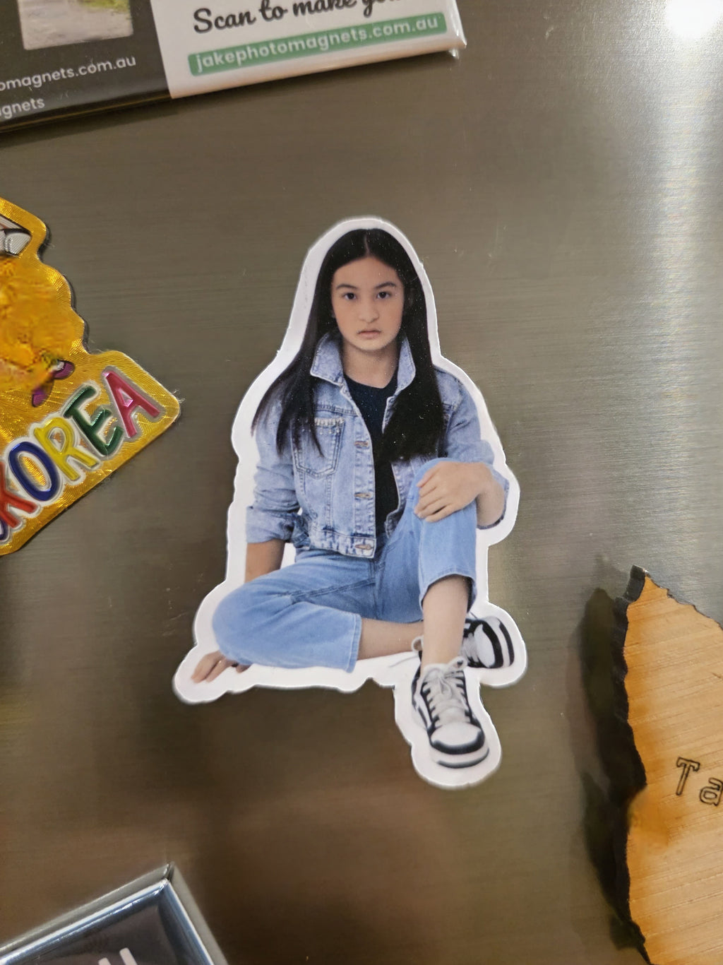 Sticker of a person sitting on a metallic surface with other stickers around