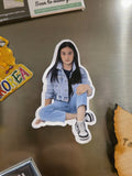 Sticker of a person sitting on a metallic surface with other stickers around