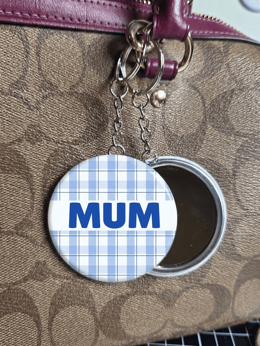 mirror key ring with 'MUM' on a plaid pattern against a brown leather background
