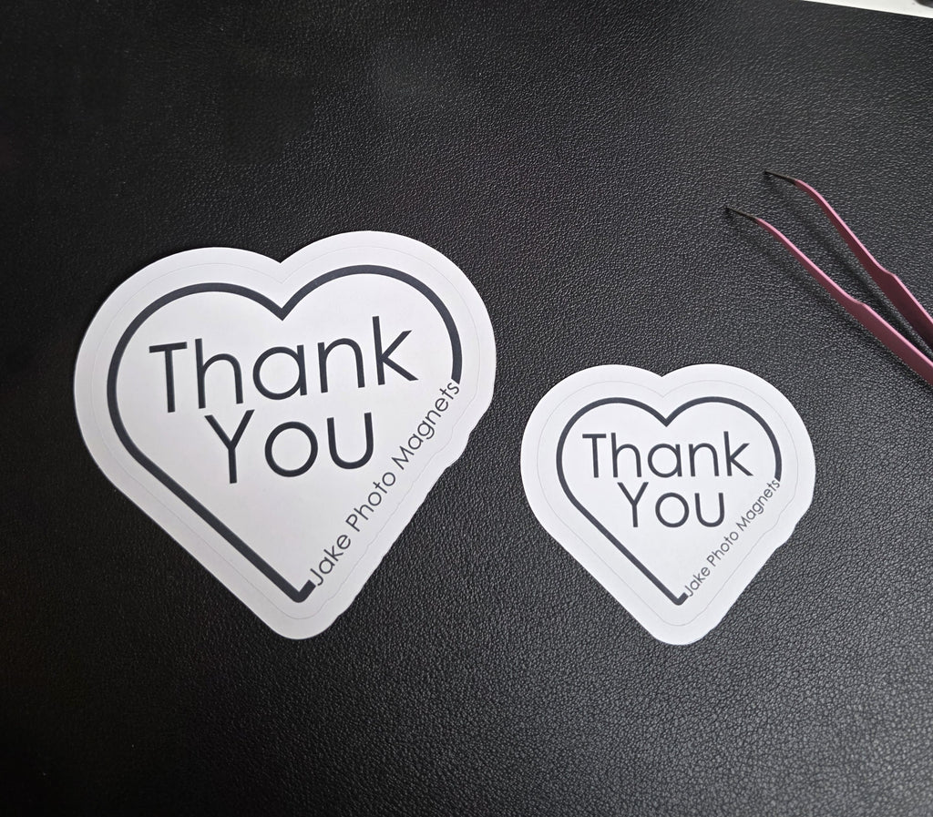 two heart-shaped custom thank you packaging stickers side-by-side to scale sizes