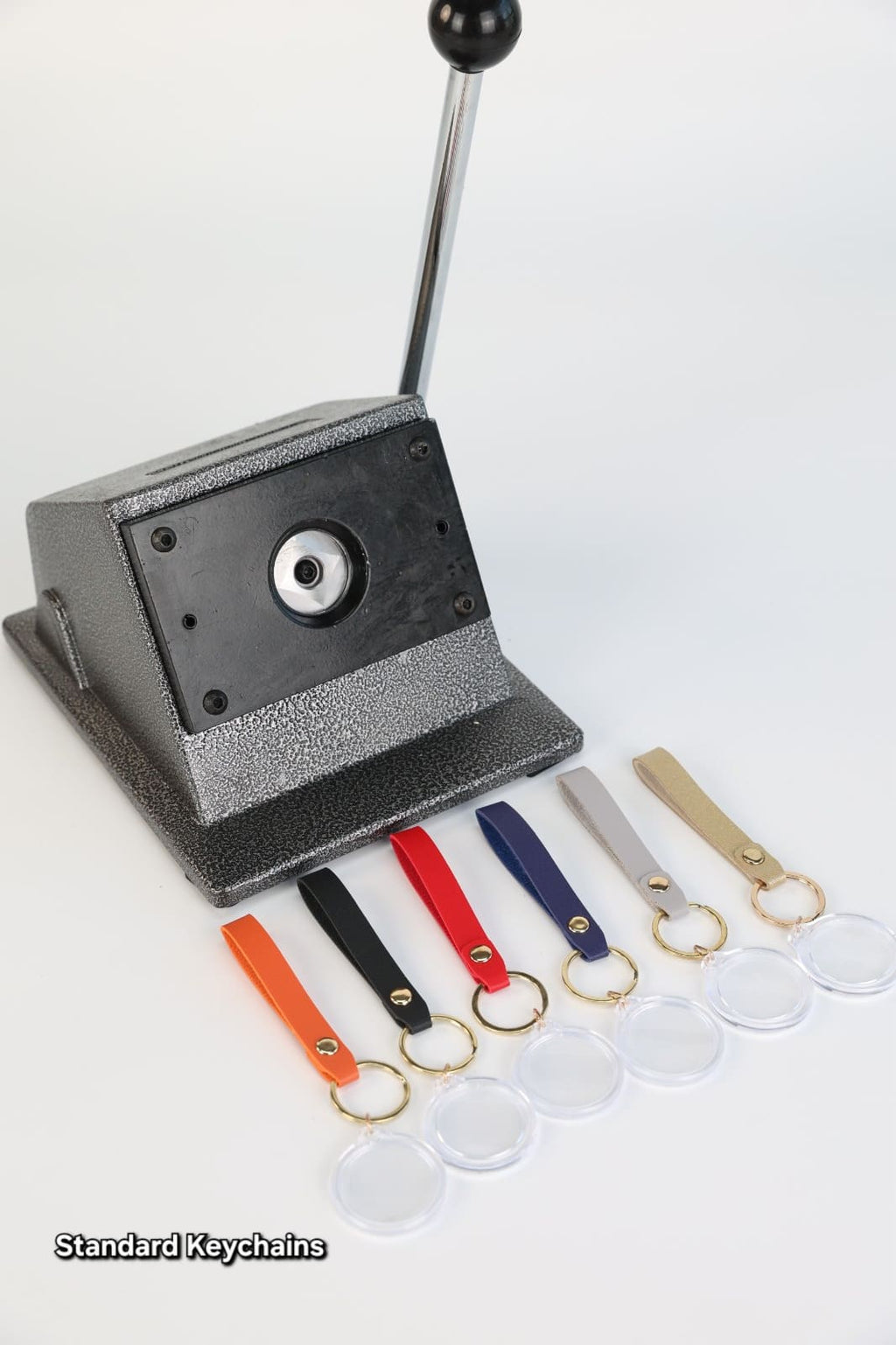 Keychain making machine with various keychains on a white background