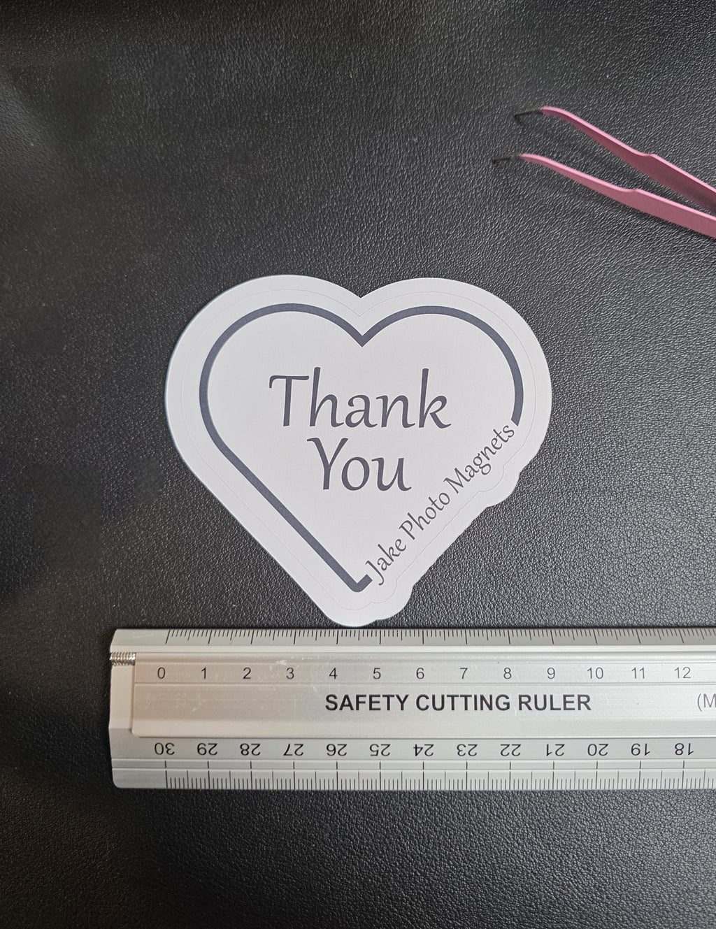 heart-shaped custom thank you packaging stickers with a ruler for scale