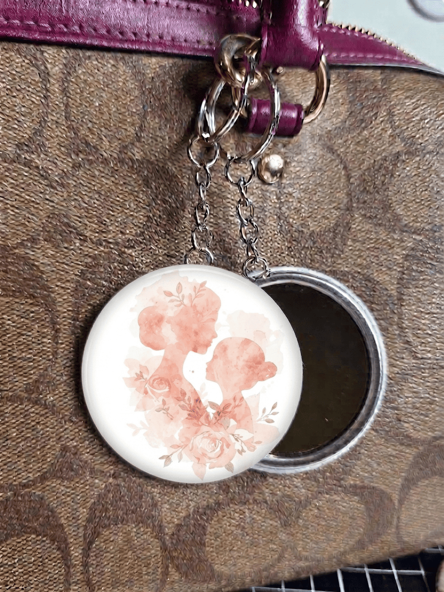 Floral design mirror key ring attached to a brown textured surface