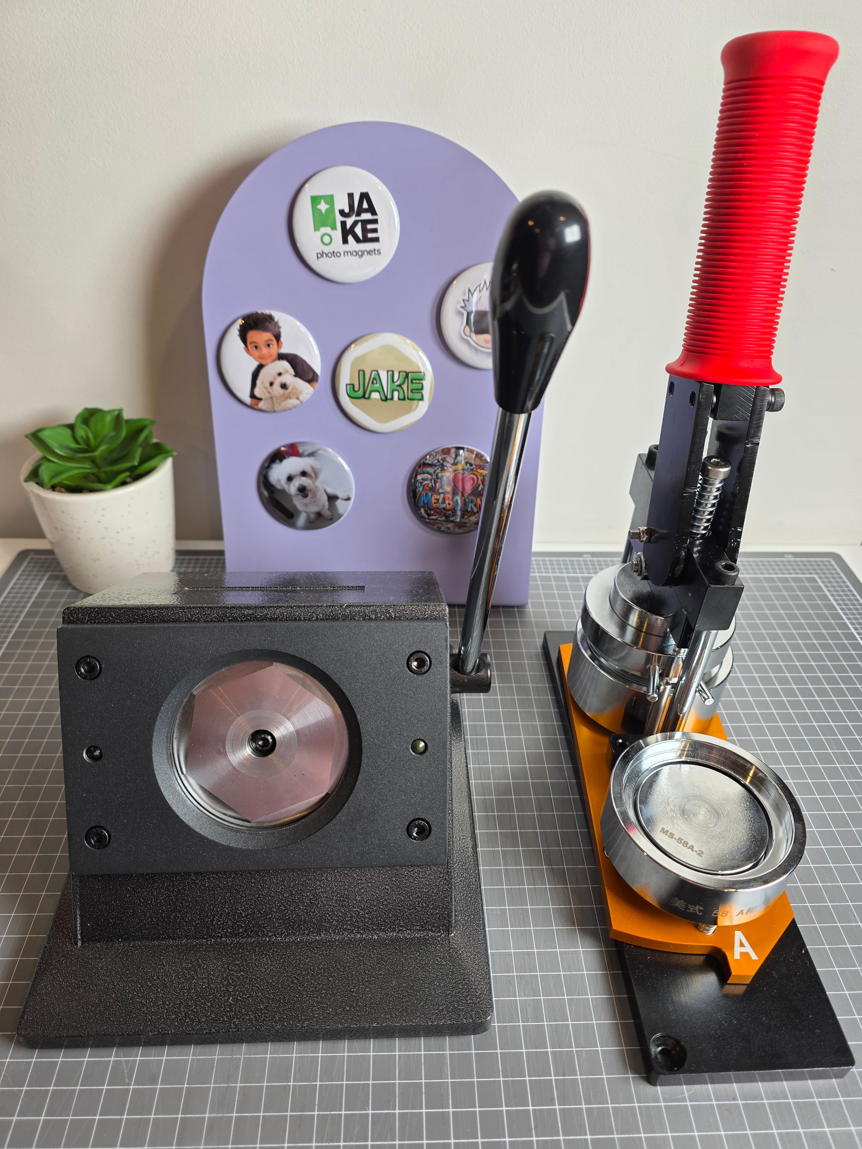 Button making machine with a roll of buttons on a gray tiled wall background