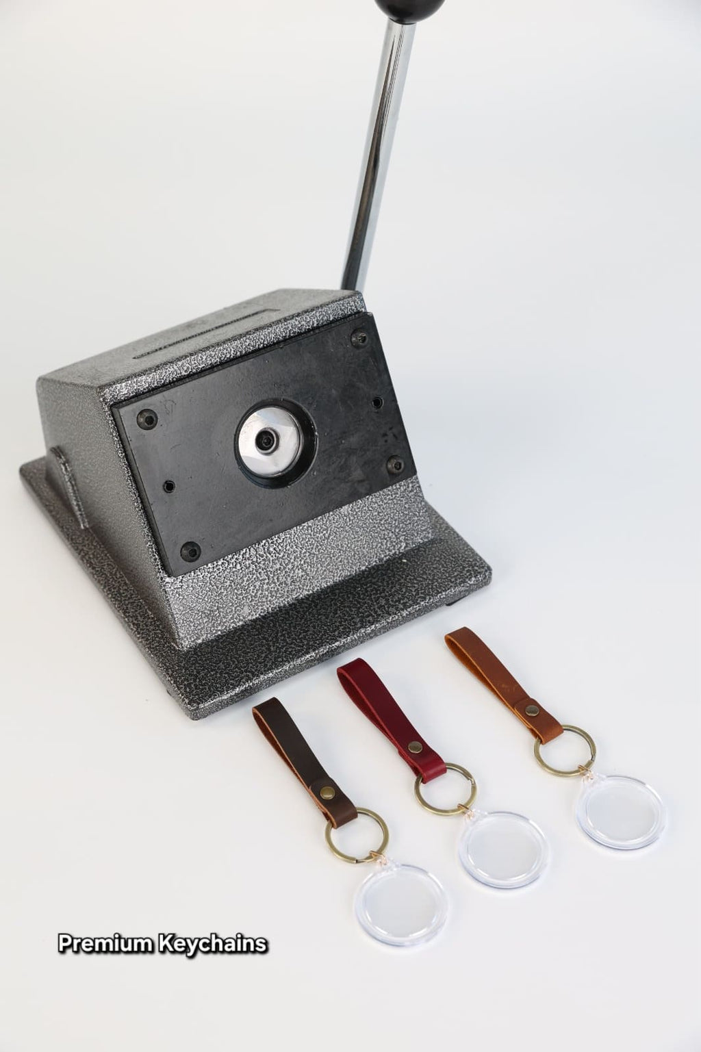 Keychain maker with three keychains and a stand on a white background