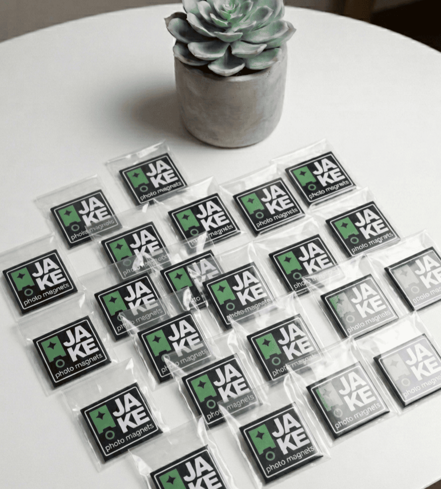 Multiple packages of JAKE photo filters on a white surface with a succulent plant in the background.