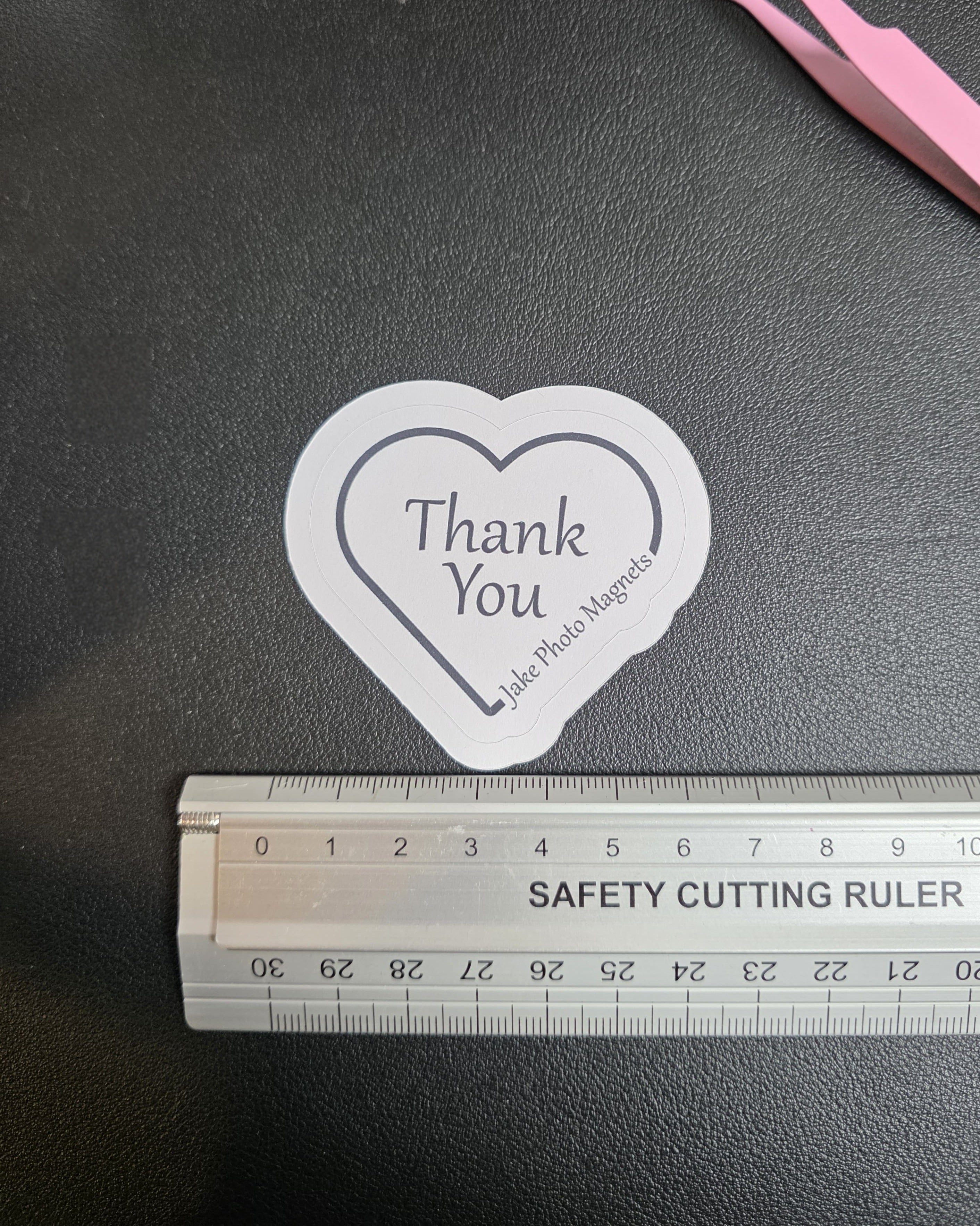heart-shaped custom thank you packaging stickers with a ruler for scale