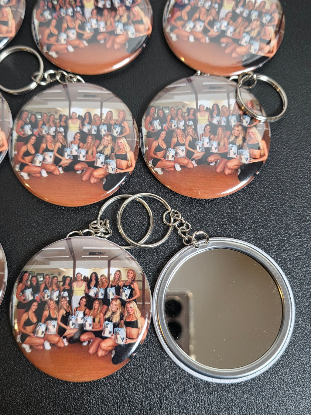 Circular keychains with a reflective surface on a dark background